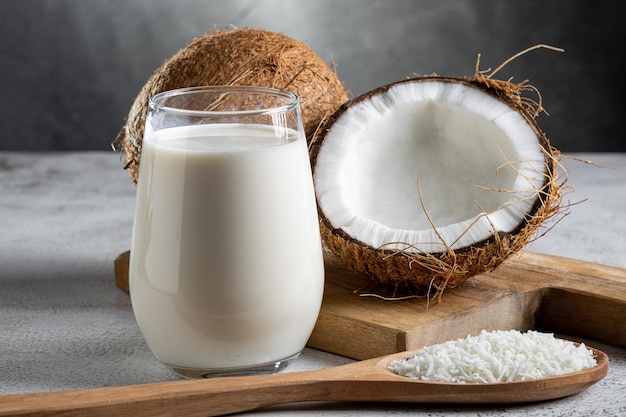 Bicchiere di latte di cocco con pezzi di cocco sul tavolo