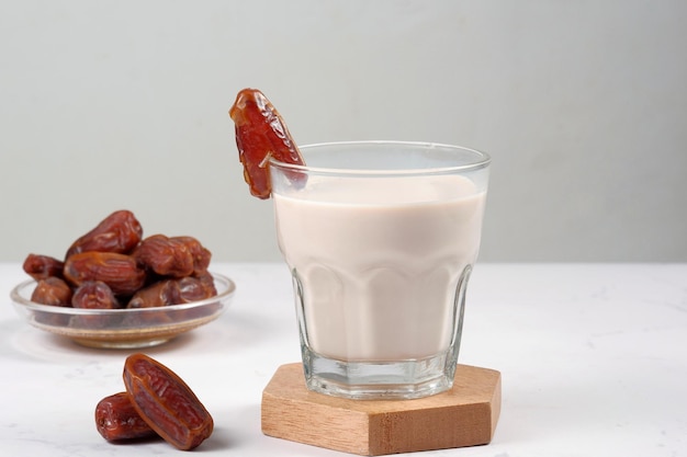 bicchiere di latte di datteri (susu kurma) su sfondo bianco