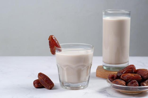 bicchiere di latte di datteri (susu kurma) su sfondo bianco