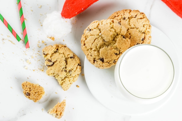 Bicchiere di latte e biscotti per Babbo Natale con cappello di Babbo Natale