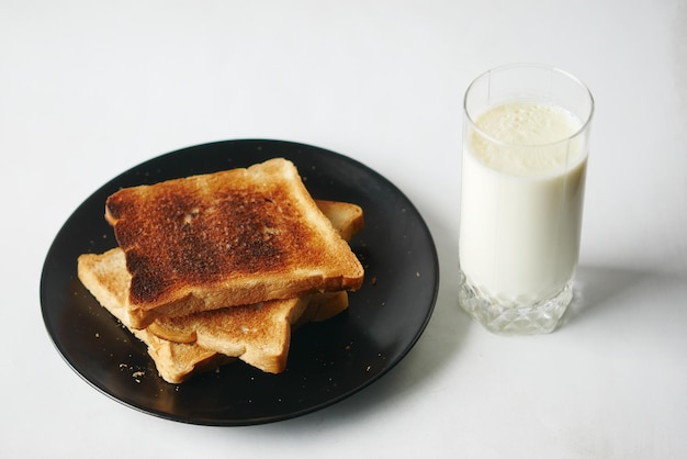 Bicchiere di latte e pane tostato sul tavolo