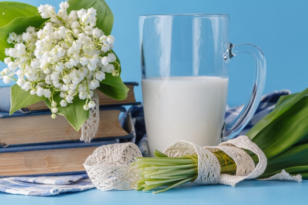 Bicchiere di latte sul blu con fiori