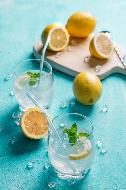 Bicchiere di limonata accanto ai limoni, blu