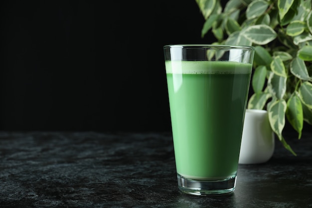 Bicchiere di matcha latte sul tavolo nero affumicato