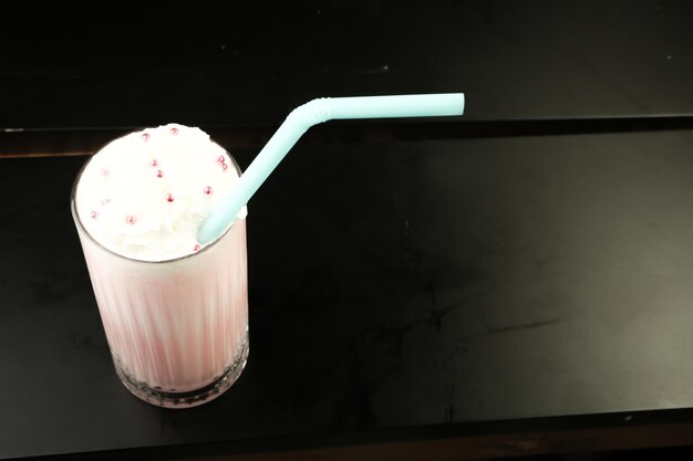 Bicchiere di milkshake al lampone con panna montata e lamponi freschi