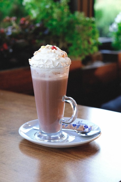 Bicchiere di milkshake al lampone con panna montata e lamponi freschi