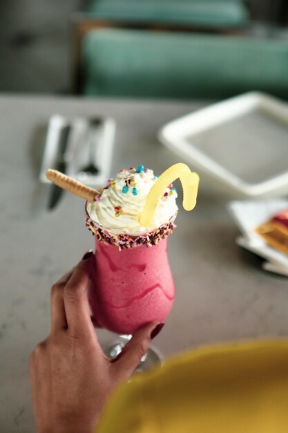 Bicchiere di milkshake al lampone con panna montata e lamponi freschi