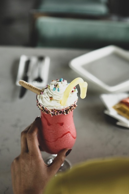 Bicchiere di milkshake al lampone con panna montata e lamponi freschi