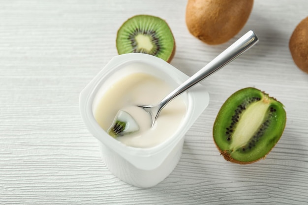 Bicchiere di plastica con yogurt kiwi squisito sulla tavola di legno