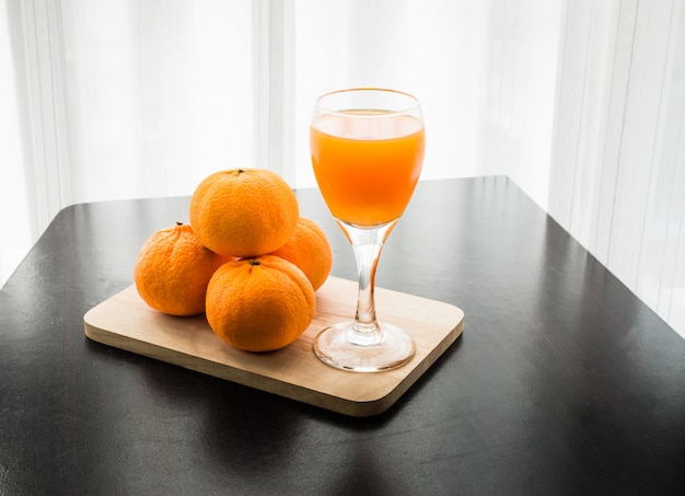 Bicchiere di succo d&#39;arancia appena spremuto con quattro arancia