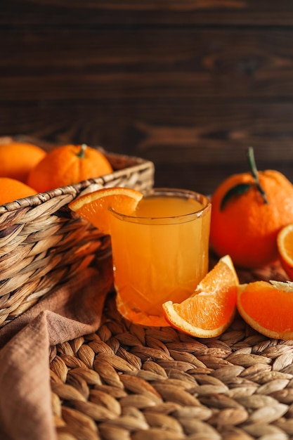 Bicchiere di succo d'arancia arance a fette e un cesto di arance Le arance sono luminose e fresche