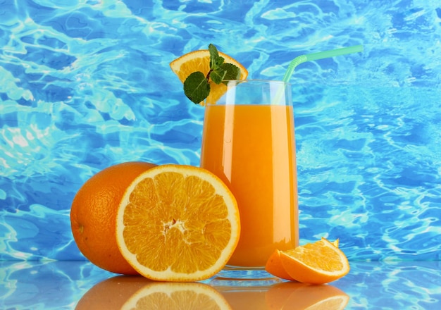 Bicchiere di succo d'arancia con menta e arancia sullo sfondo del mare