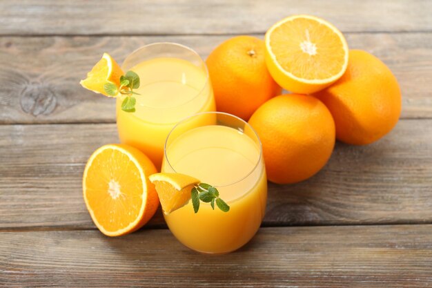 Bicchiere di succo d'arancia e fette sul fondo della tavola in legno