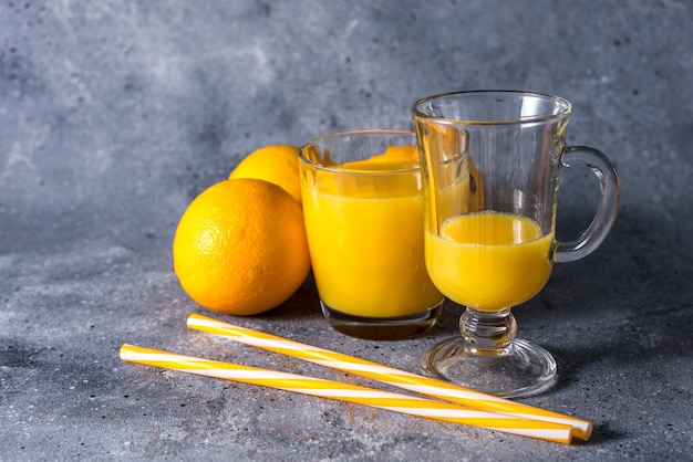 Bicchiere di succo d'arancia fresco, frutta e fette d'arancia mature