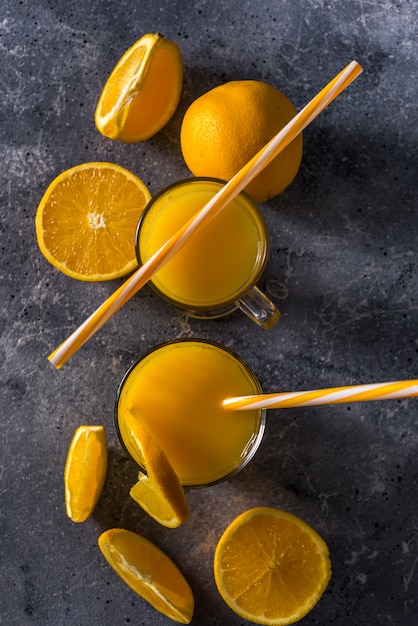 Bicchiere di succo d'arancia fresco, frutta e fette d'arancia mature