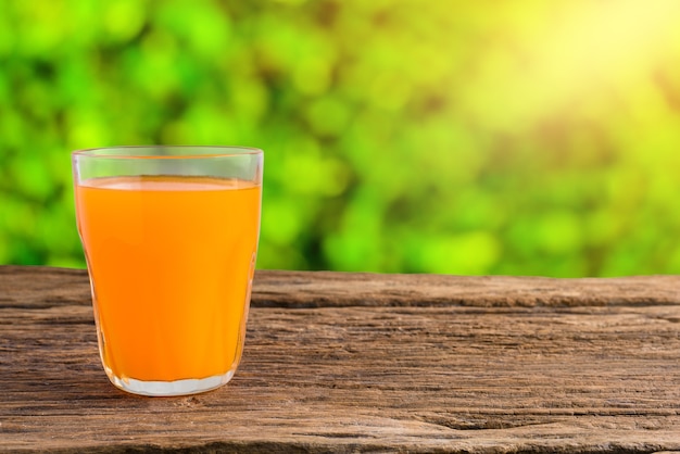 Bicchiere di succo d&#39;arancia fresco sul tavolo di legno