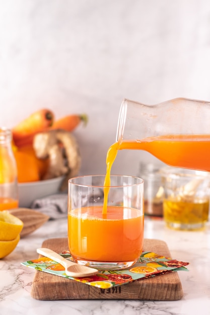 Bicchiere di succo di carota su sfondo di marmo