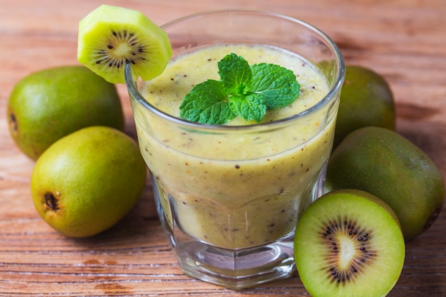 bicchiere di succo di kiwi con frutta fresca sul tavolo di legno