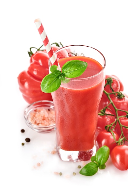 Bicchiere di succo di pomodoro fresco, basilico e pomodori isolati su sfondo bianco. Con copia spazio.