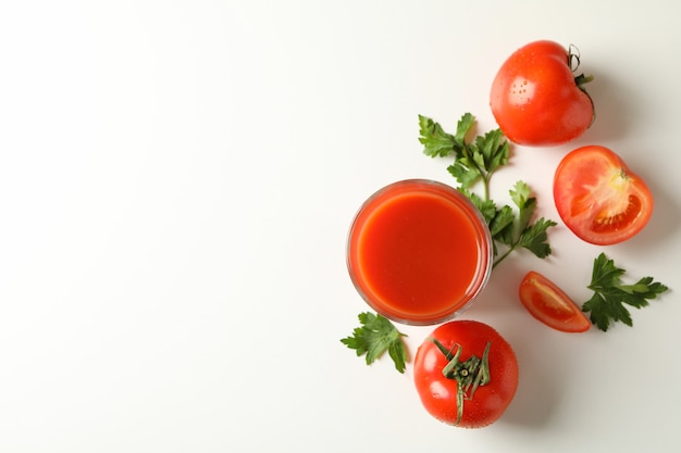 Bicchiere di succo di pomodoro, pomodori e prezzemolo su bianco