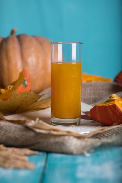 Bicchiere di succo di zucca su superficie di legno. Avvicinamento