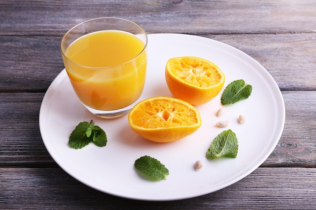 Bicchiere di succo e mandarino dolce maturo sul tavolo di legno