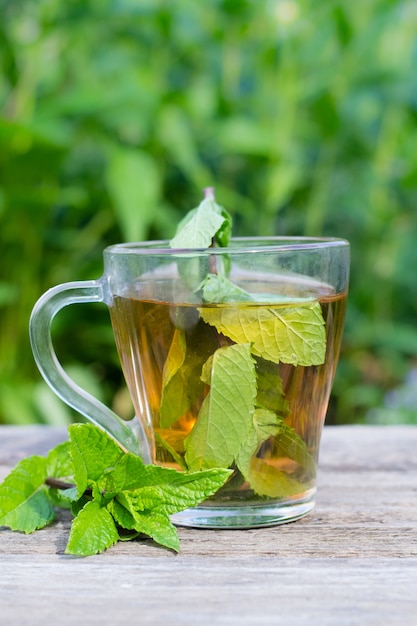 bicchiere di tè alla menta sul tavolo di legno all'aperto