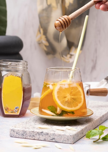 Bicchiere di tè freddo al limone fresco con citronella sul tavolo di marmo bianco. Messa a fuoco selettiva. Avvicinamento