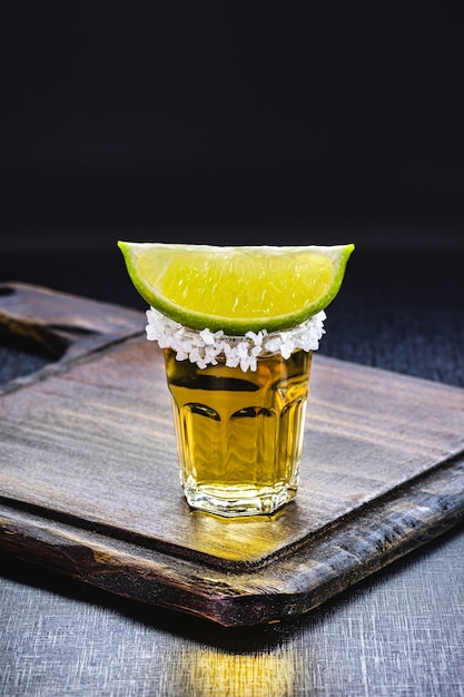 Bicchiere di tequila, superficie nera, bevanda tipica messicana