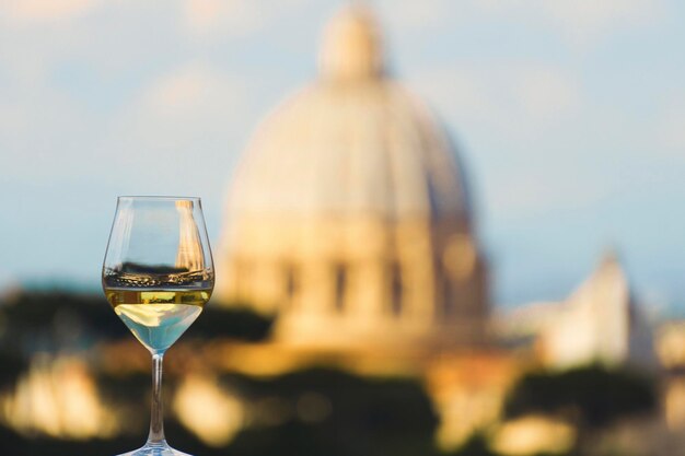 Bicchiere di vino bianco italiano con la Basilica di San Pietro Roma sullo sfondo