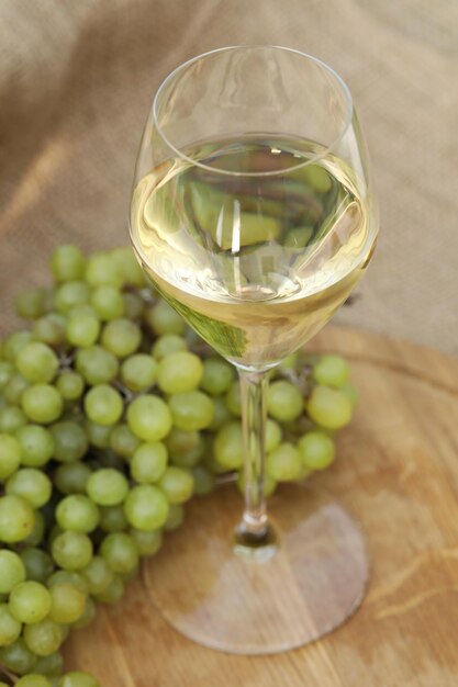 bicchiere di vino bianco su fondo di legno con uva