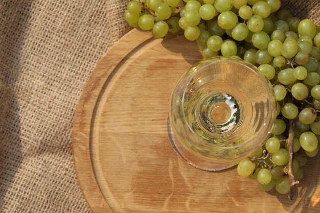 bicchiere di vino bianco su fondo di legno con uva