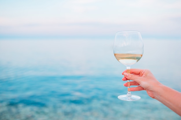 Bicchiere di vino bianco sulla spiaggia tropicale