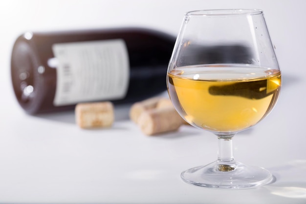 Bicchiere di vino bianco sullo sfondo di una bottiglia indistinta