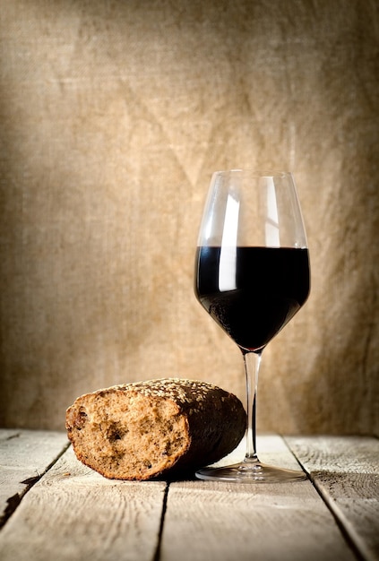 Bicchiere di vino e pane e sul tavolo di legno