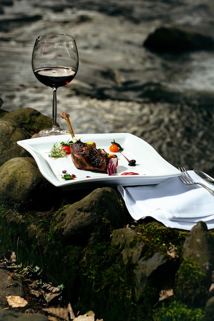 Bicchiere di vino e pasto vicino all'acqua