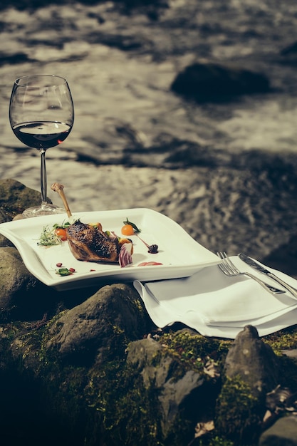 Bicchiere di vino e pasto vicino all'acqua