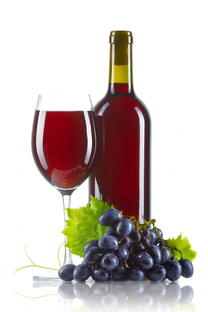 Bicchiere di vino rosso con bottiglia e uva matura isolato