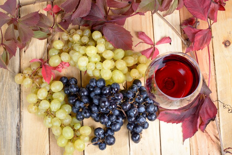 Bicchiere di vino rosso con molti grappoli d'uva