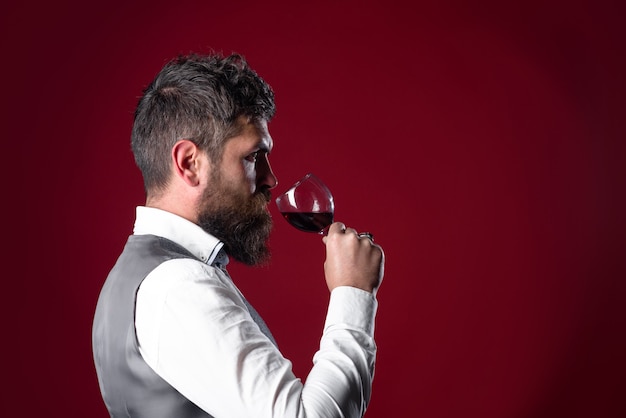 Bicchiere di vino rosso degustazione alcol uomo barbuto con bicchiere di vino uomo beve vino rosso uomo con