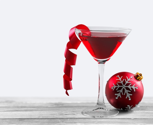 Bicchiere di vino rosso e decorazioni natalizie sullo sfondo
