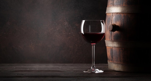 Bicchiere di vino rosso e vecchia botte di legno