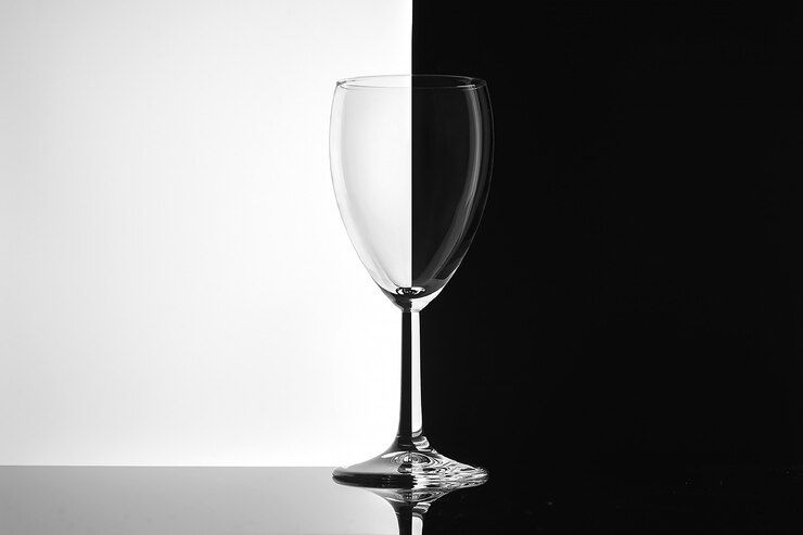 Bicchiere di vino vuoto sul primo piano bianco e nero del fondo.