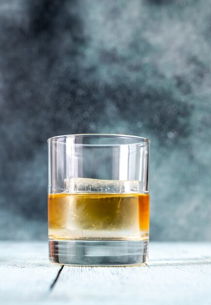 Bicchiere di whisky bourbon con cubetto di ghiaccio