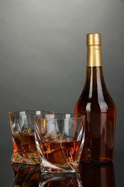 Bicchiere di whisky con bottiglia su sfondo scuro