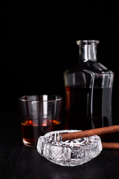 Bicchiere di whisky con sigaro di fumo. Whisky, tabacco.