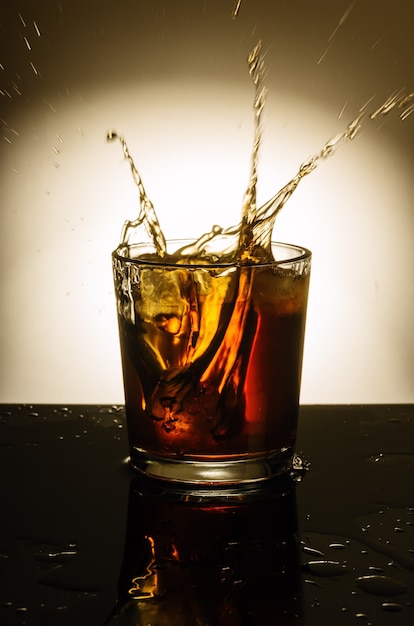 Bicchiere di whisky con spray dal ghiaccio lanciato