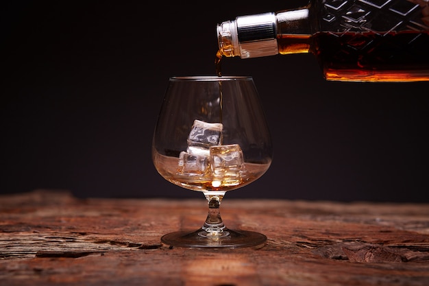 Bicchiere di whisky sul tavolo di legno