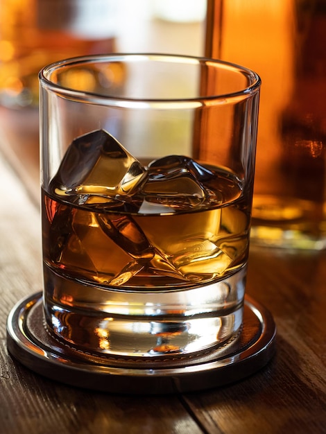 Bicchiere di whisky sulle rocce su un bar in legno
