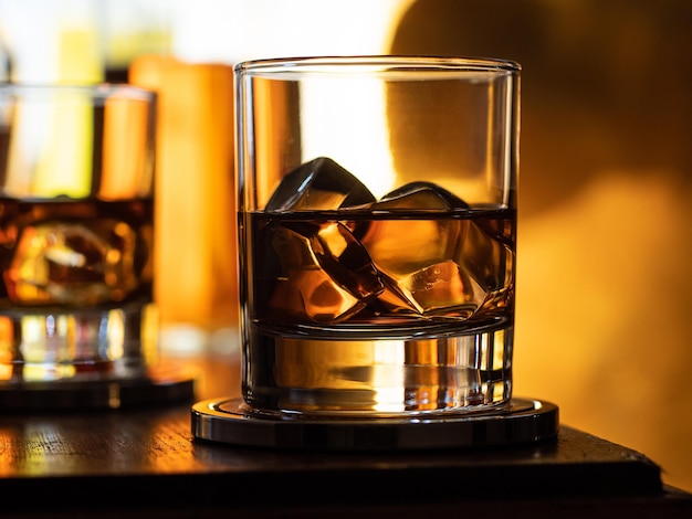 Bicchiere di whisky sulle rocce su un bar in legno